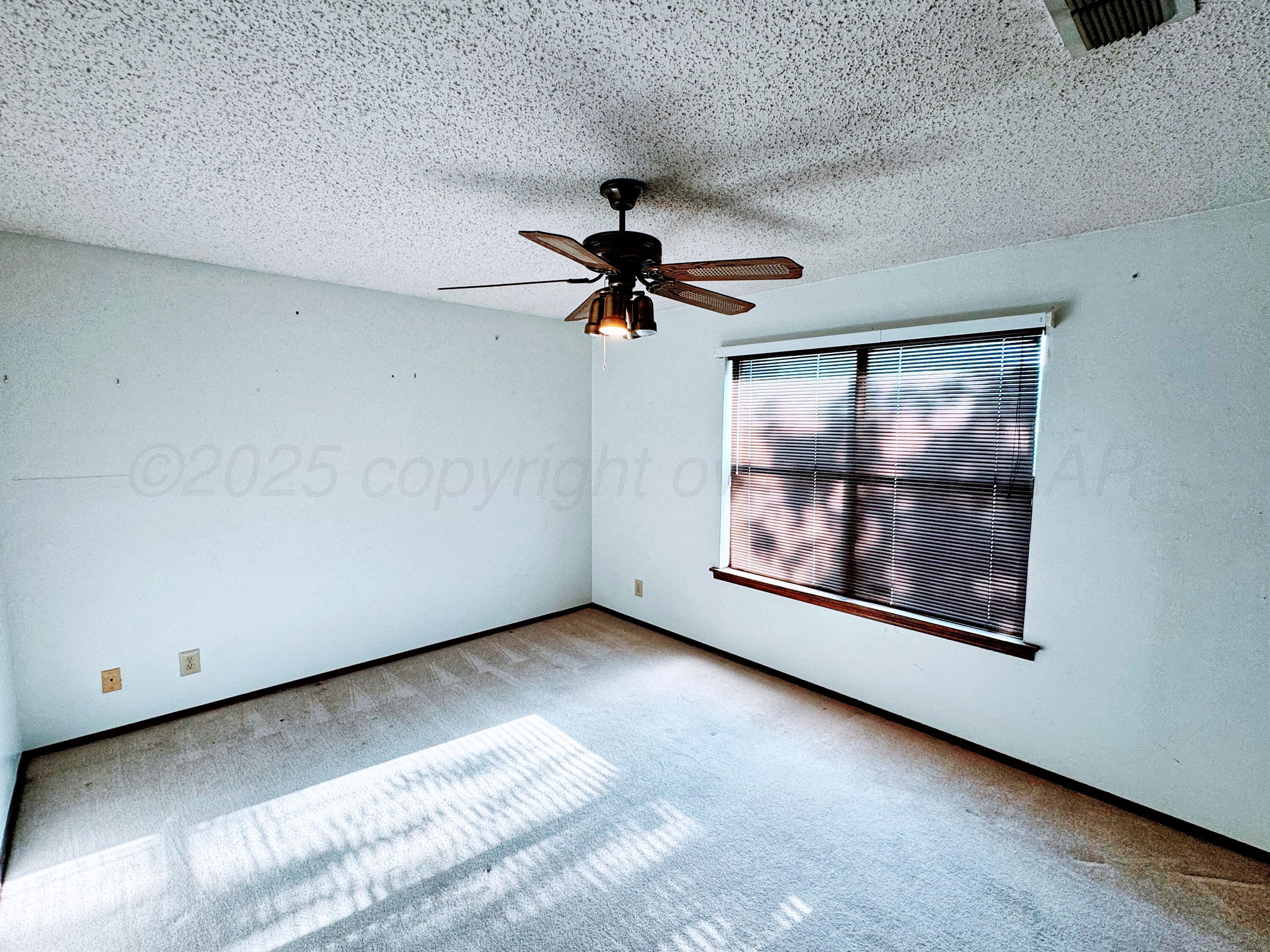 1905 Utah Street Perryton, TX 79070 - Photo 4 of 22 a view of room with ceiling fan and window