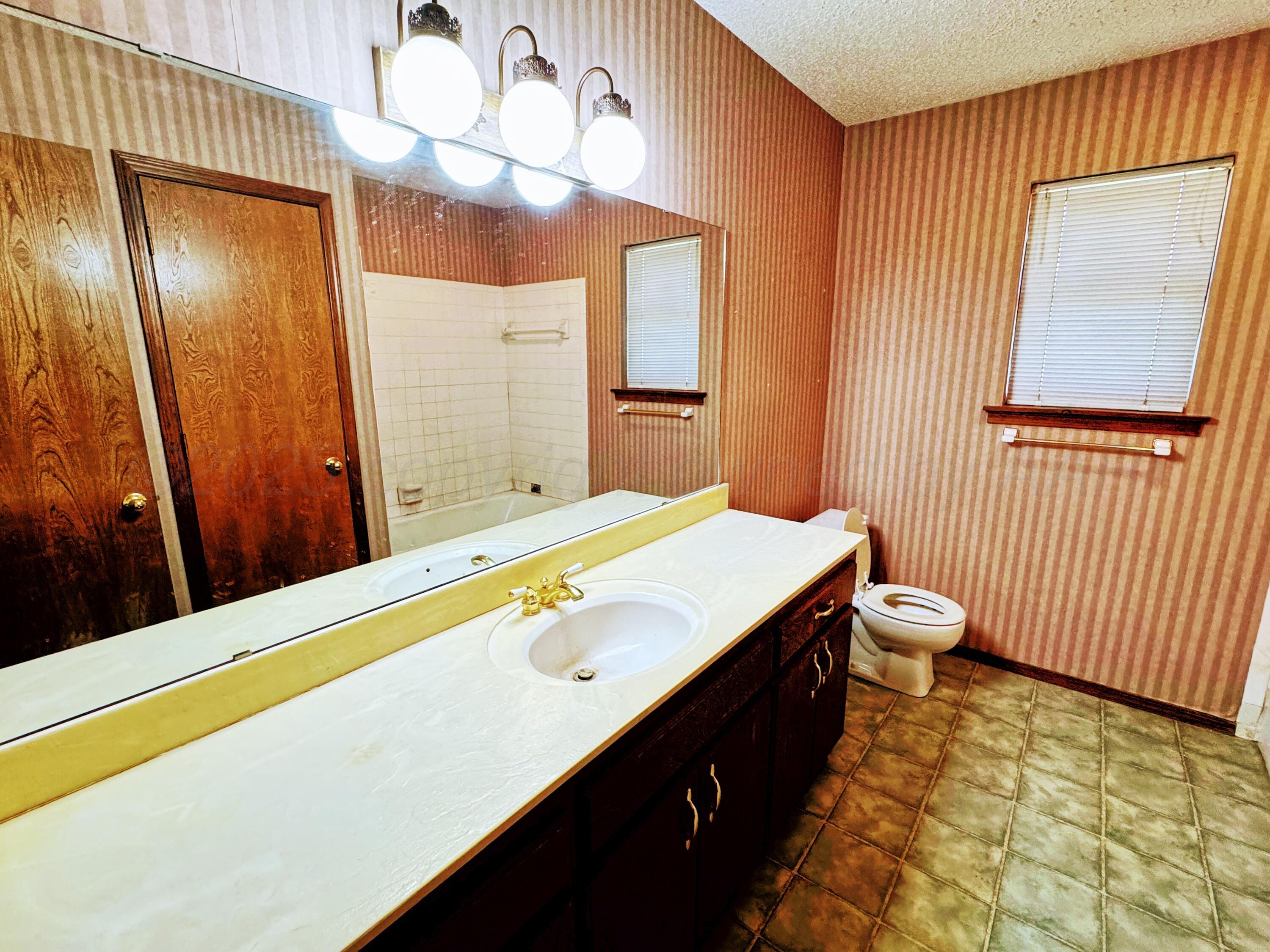 1905 Utah Street Perryton, TX 79070 - Photo 5 of 22 a bathroom with a sink and a mirror