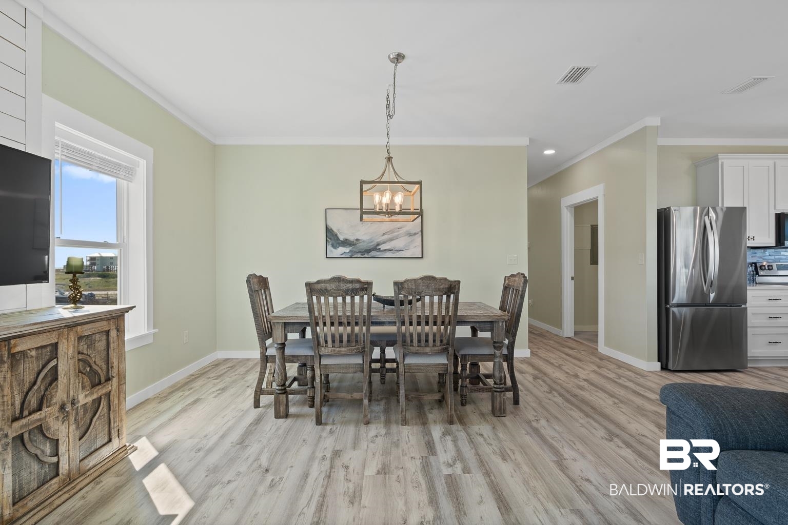 2586 Muscogee Road Gulf Shores, AL 36542 - Photo 20 of 55 Dining space featuring crown molding, light hardwood / wood-style floors, and a notable chandelier