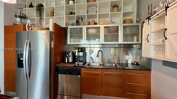 a kitchen with stainless steel appliances granite countertop a refrigerator and a sink