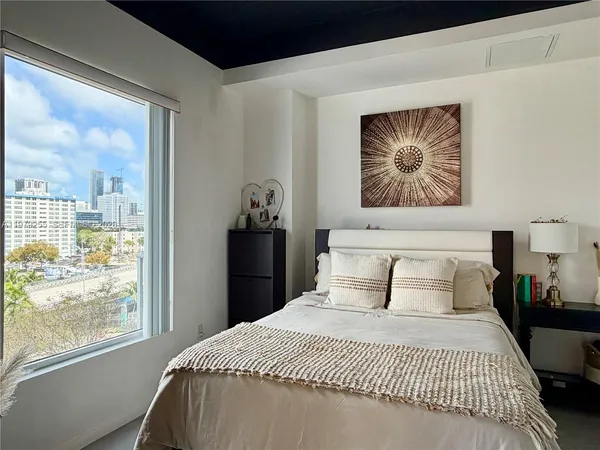 a bedroom with a bed and a large window