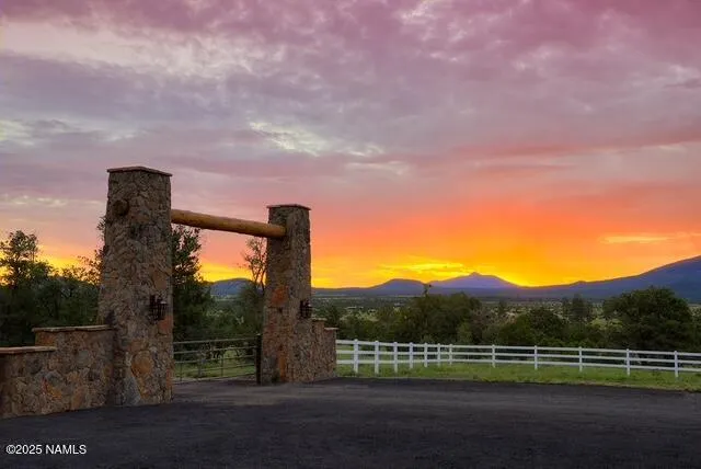 a view of a road with a yard and wooden fence