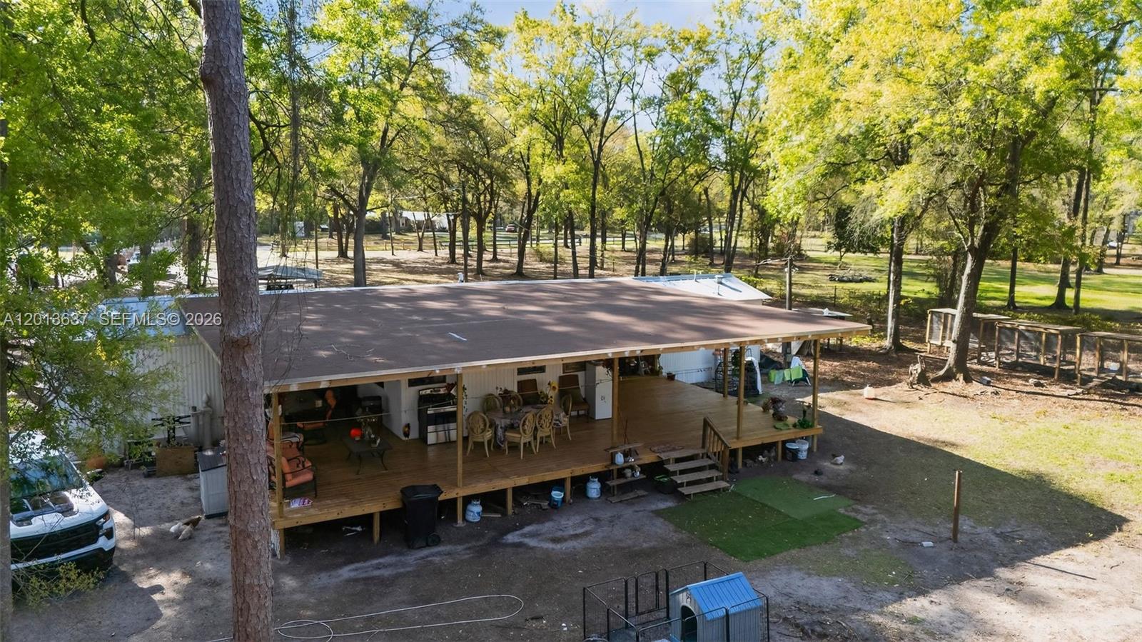 2522 Northwest 121st Avenue Gainesville, FL 32609 - Photo 1 of 40 a view of a patio with table and chairs a fire pit and large trees