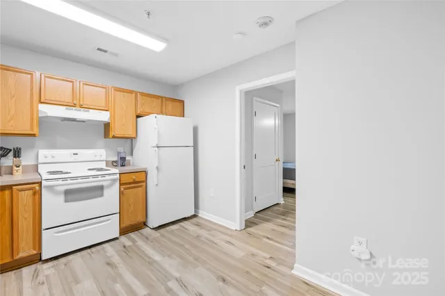 a kitchen with white cabinets and white appliances