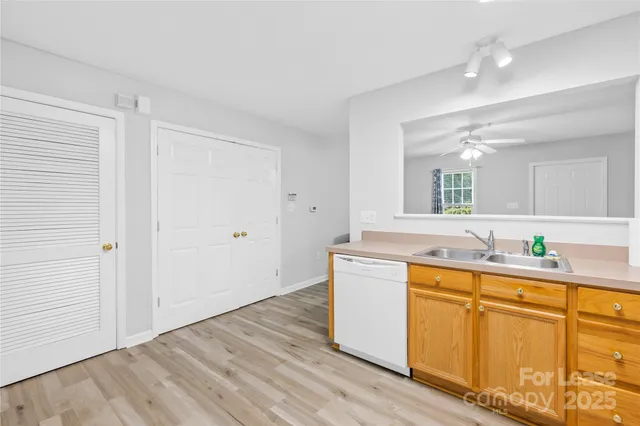 a kitchen with stainless steel appliances granite countertop a sink cabinets and wooden floor