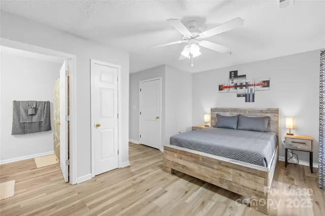 a spacious bedroom with a bed and a chandelier