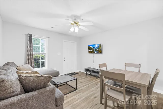 a living room with furniture a ceiling fan and a window