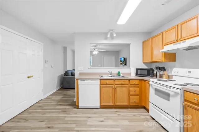 a large kitchen with a stove a sink dishwasher and a refrigerator