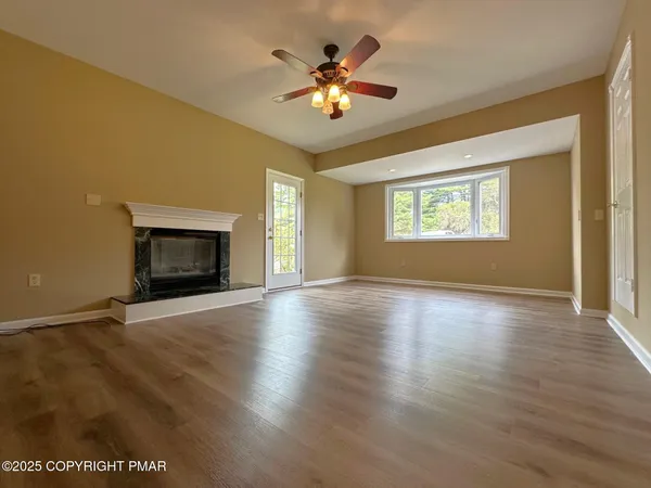 a view of an empty room with a fireplace and a window
