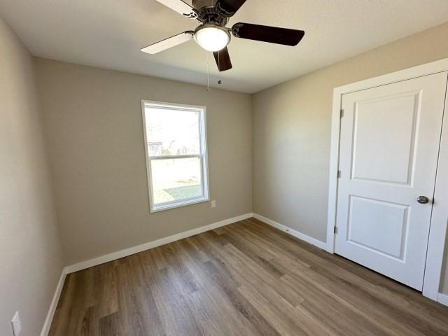 1107 North 4th Street Merkel, TX 79536 - Photo 11 of 16 a view of an empty room with wooden floor and a window