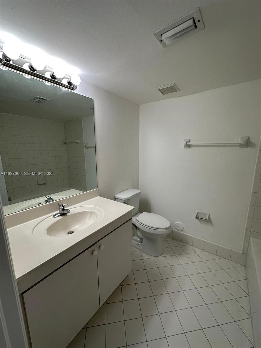 2911 Southeast 13th Road, Unit 10140 Homestead, FL 33035 - Photo 14 of 22 a bathroom with a sink a toilet and mirror