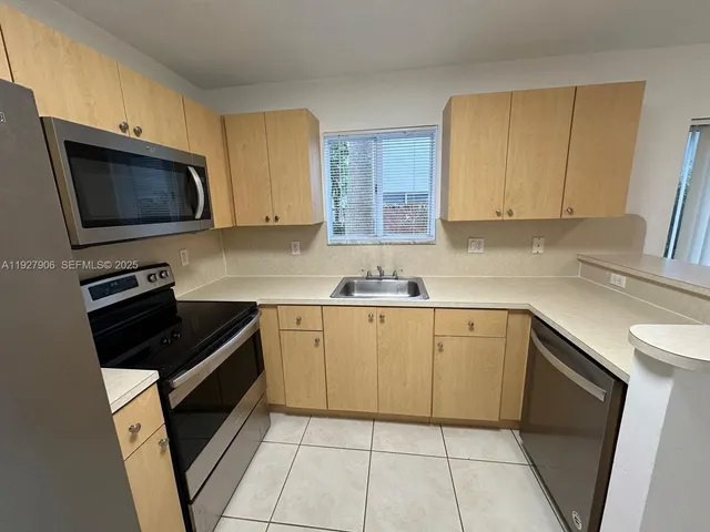a kitchen with stainless steel appliances granite countertop a refrigerator and a stove