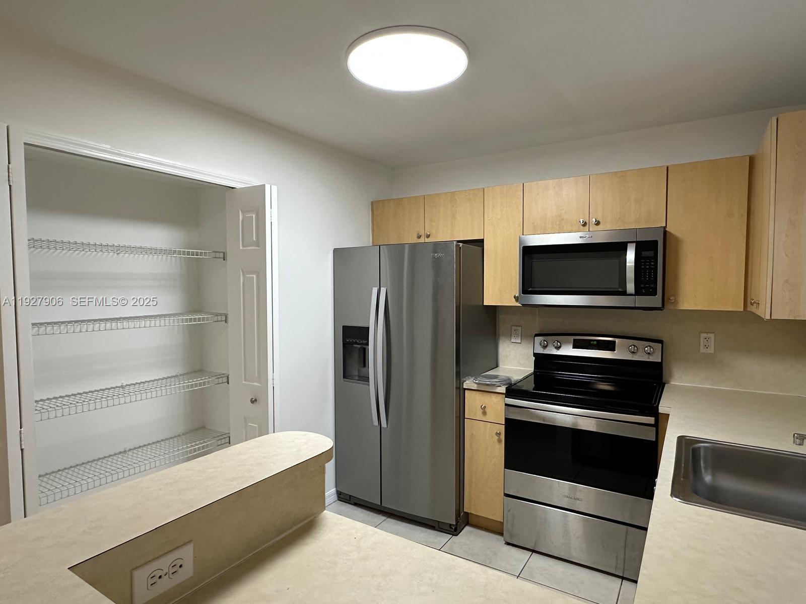 2911 Southeast 13th Road, Unit 10140 Homestead, FL 33035 - Photo 10 of 22 a kitchen with a refrigerator stove and microwave