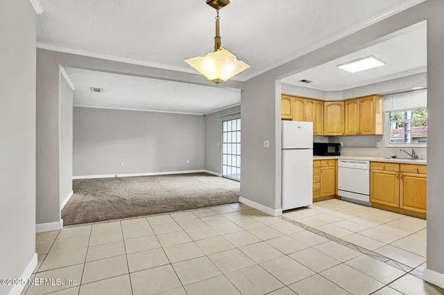 a kitchen with a refrigerator a stove top oven a sink and a window