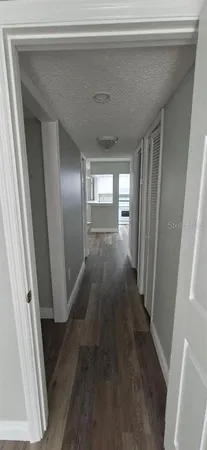 an empty room with wooden floor sink and window