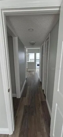 an empty room with wooden floor sink and window