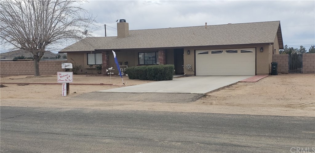 15620 Apache Road Apple Valley, CA 92307 - Photo 1 of 1 a front view of a house with garden