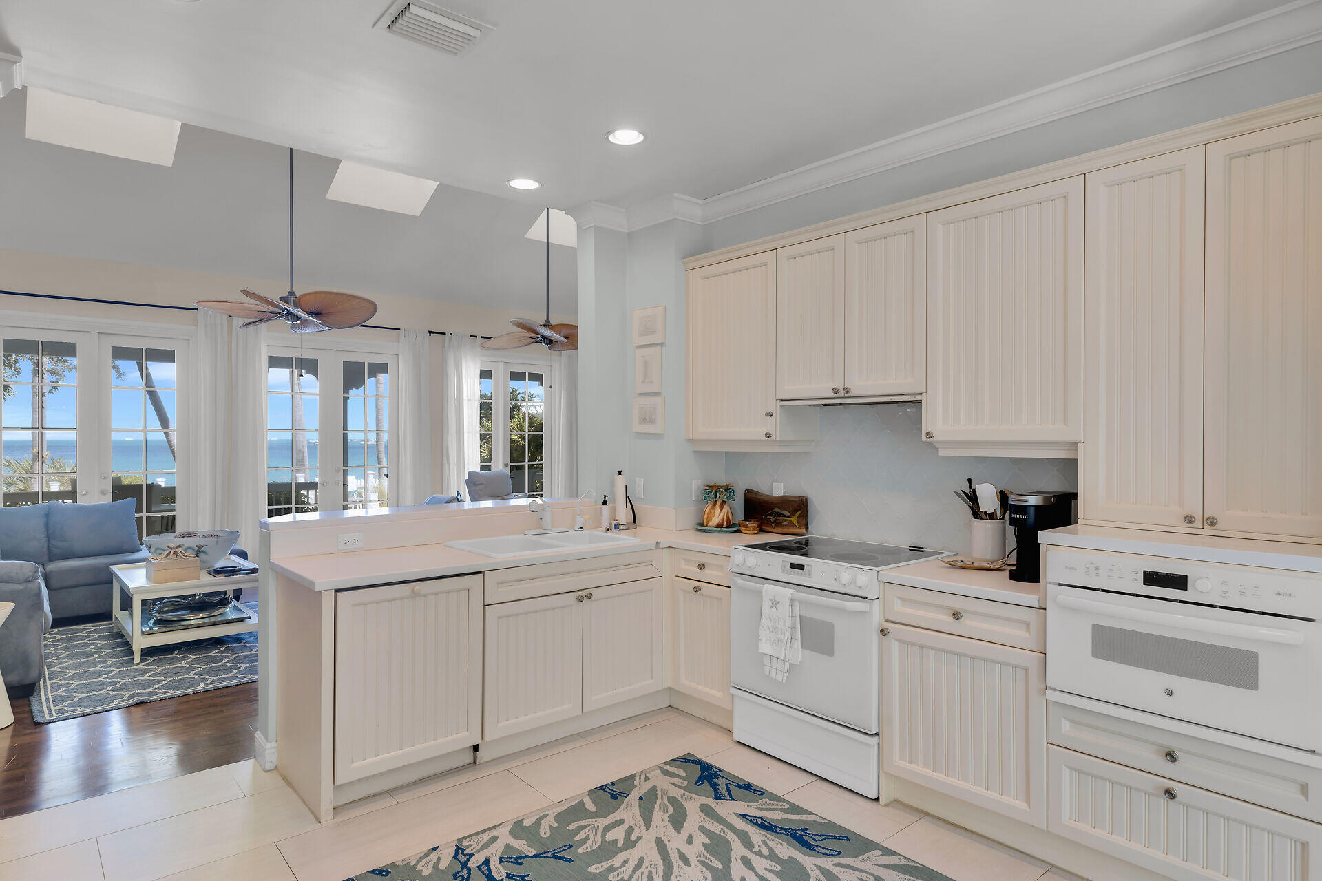 5 Sunset Key Drive Key West, FL 33040 - Photo 16 of 47 a kitchen with a sink dishwasher and white cabinets with wooden floor