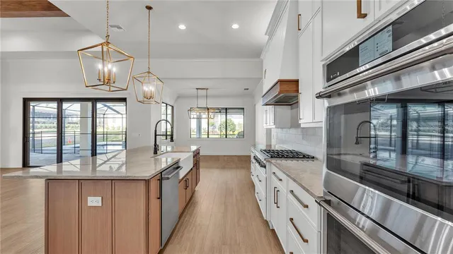a kitchen with kitchen island white cabinets and stainless steel appliances