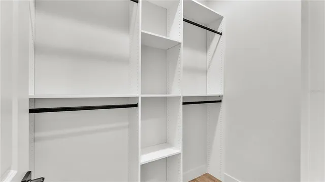an empty room with wooden floor and a ceiling fan