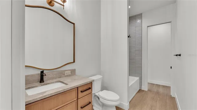 a view of a room with wooden floor and a ceiling fan