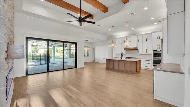 a large kitchen with stainless steel appliances a large counter top a sink a stove and a refrigerator