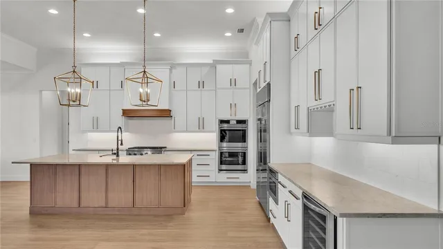 a kitchen with stainless steel appliances granite countertop a sink a stove and a refrigerator