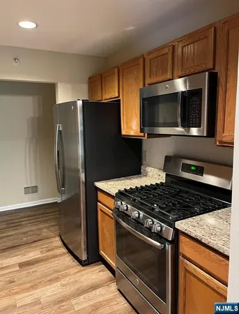 a kitchen with granite countertop a stove and a microwave with cabinets