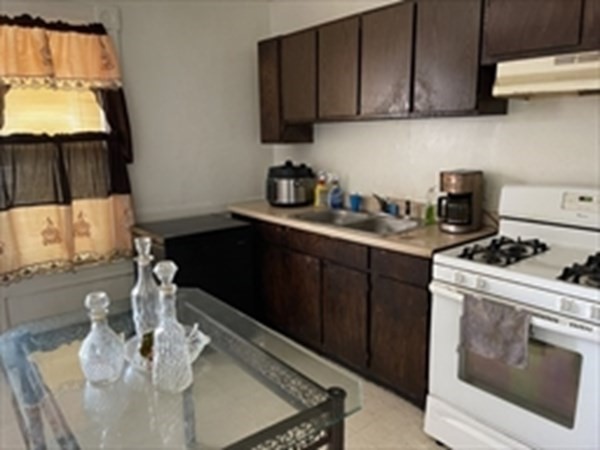 89-91 Ashley Street Springfield, MA 01105 - Photo 12 of 26 a kitchen with stainless steel appliances a stove a sink a microwave a refrigerator and cabinets