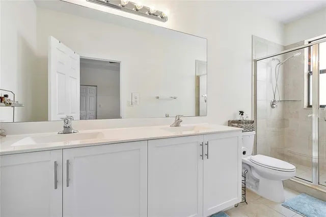a bathroom with a granite countertop sink mirror and toilet