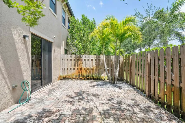 a view of backyard with potted plants and wooden fence