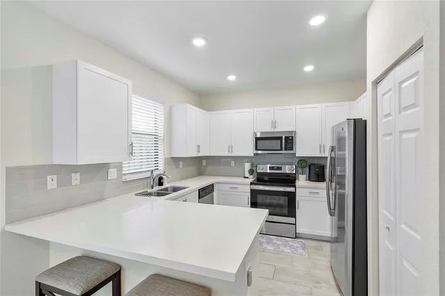 a kitchen that has a sink stainless steel appliances a counter top space and cabinets