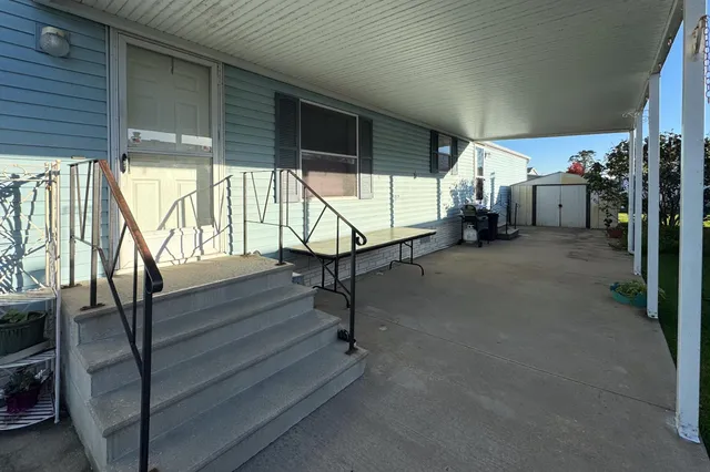 a view of an empty room with wooden floor and furniture