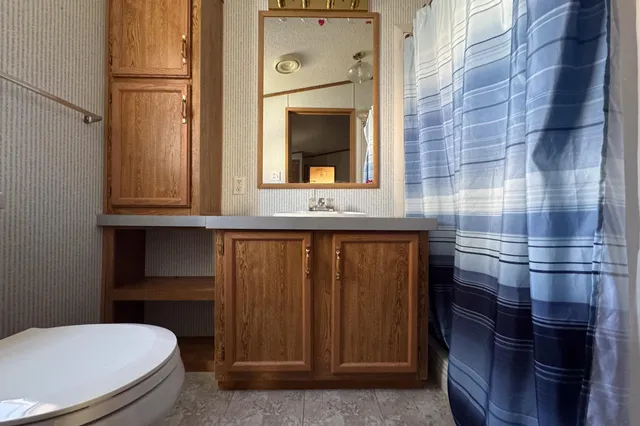 a bathroom with a toilet a sink and mirror