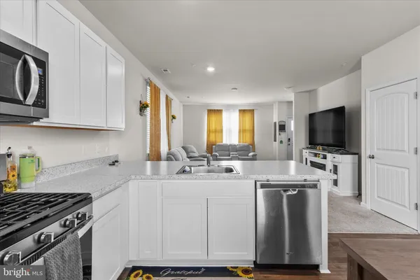 a kitchen with a sink a stove and cabinets