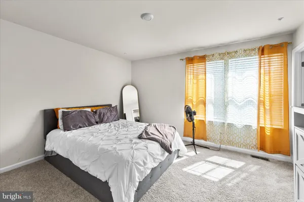 a bedroom with a bed and a large window