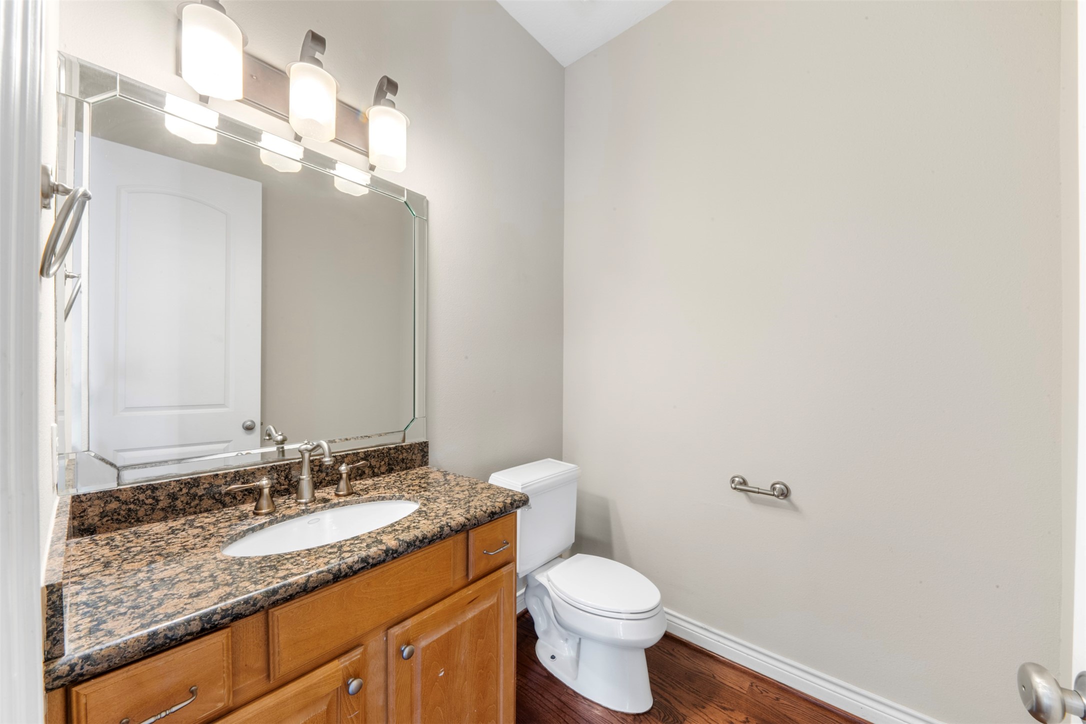 6524 Calder Street Houston, TX 77007 - Photo 17 of 28 a bathroom with a granite countertop sink a toilet and a mirror