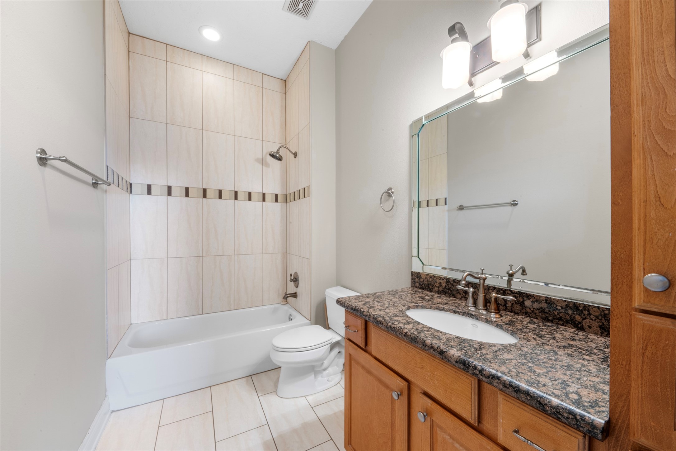 6524 Calder Street Houston, TX 77007 - Photo 25 of 28 a bathroom with a granite countertop sink a toilet a mirror and shower