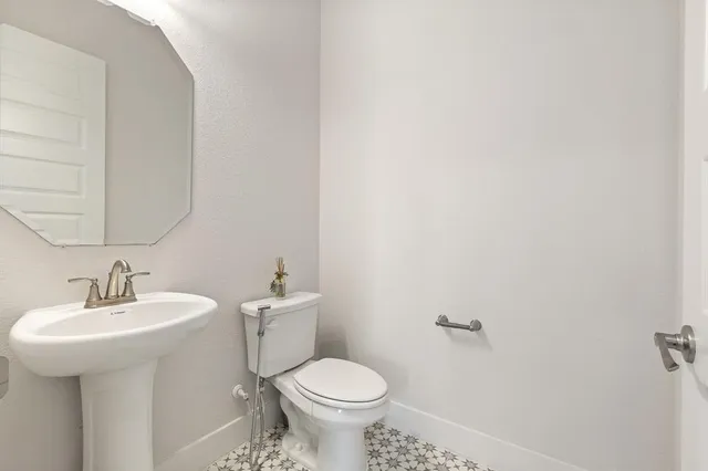 a bathroom with a sink toilet and a mirror