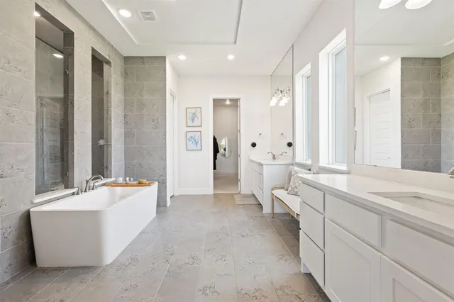 a large spacious bathroom with a tub sink and mirror