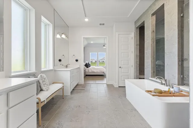 a spacious bathroom with a double vanity sink tub and mirror