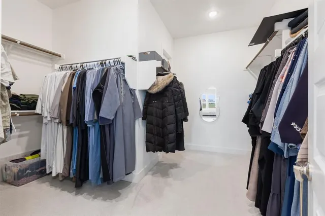 a view of walk in closet with clothes and shoes