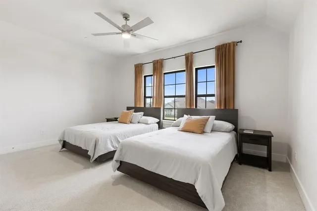 a bedroom with two beds and a large window