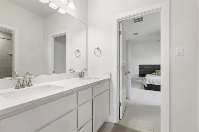 a en suite bathroom with a granite countertop sink a mirror and a