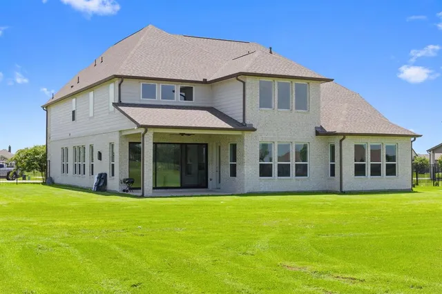 a view of a white house with a large yard and large trees