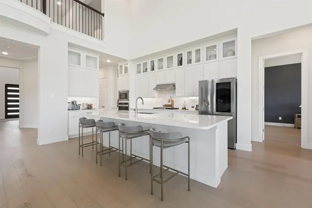 a kitchen with kitchen island granite countertop a sink and a refrigerator