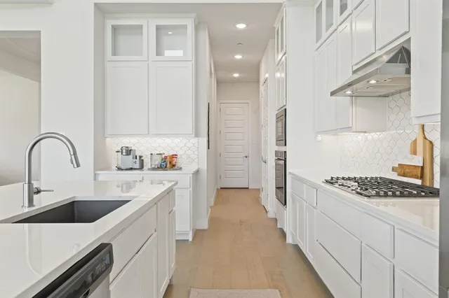 a kitchen with kitchen island stainless steel appliances a sink stove and refrigerator