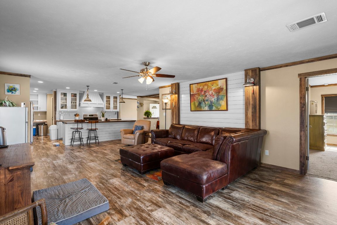 498 William Pettus Road Maxwell, TX 78656 - Photo 10 of 27 a living room with couches and kitchen view with wooden floor
