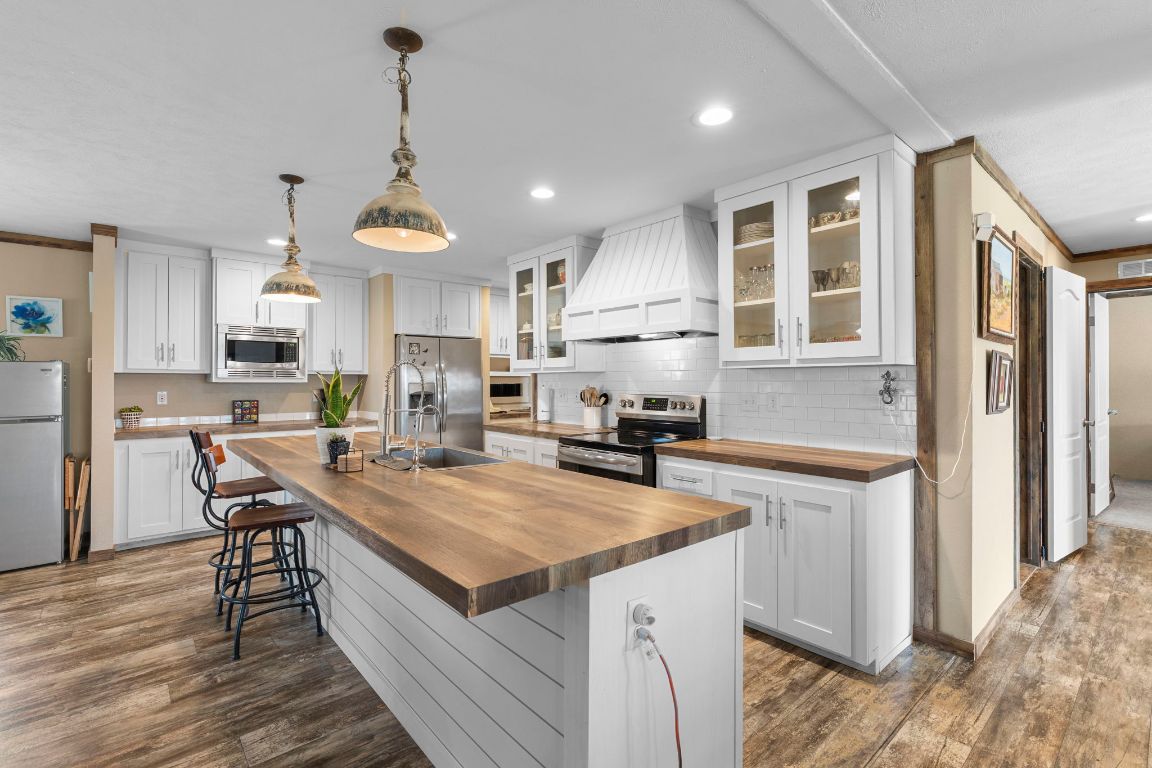498 William Pettus Road Maxwell, TX 78656 - Photo 2 of 27 a kitchen with a stove a refrigerator and a wooden cabinets