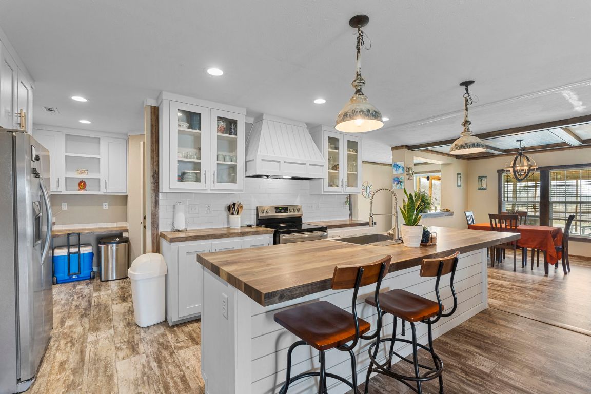 498 William Pettus Road Maxwell, TX 78656 - Photo 6 of 27 a kitchen with stainless steel appliances granite countertop a kitchen island a stove a table and chairs